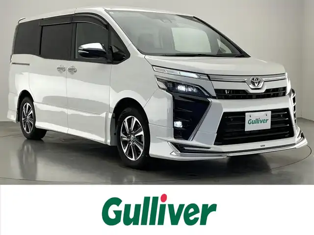 トヨタ ヴォクシー ZS 煌Ⅲ 愛知県 2021(令3)年 5.3万km ホワイトパールクリスタルシャイン 7人乗り/モデリスタエアロ　（フロント/リア）/純正12.1インチフリップダウンモニター/黒ハーフレザーシート/純正10インチSDナビ【NSZN-Z68T】/(HDMI/AM/FM/Bluetooth/CD/DVD/フルセグTV)/バックカメラ/ビルトインETC/オートライト/Toyota Safety Sense/・PCS(プリクラッシュセーフティ)/・LDA(レーンディパーチャーアラート)/・オートマチックハイビーム/・先行車発進告知機能/PKSB(パーキングサポートブレーキ)/クルーズコントロール/クリアランスソナー/コーナーセンサー/アイドリングストップ/盗難防止装置/横滑り防止機能/社外前後ドライブレコーダーCOMTEC【DC-DR652】/USB充電ソケット/電格ウィンカーミラー/プッシュスタート/純正フロアマット/純正16インチアルミホイール/ステアリングスイッチ/ISOFIX/フロントフォグランプ/ドアバイザー