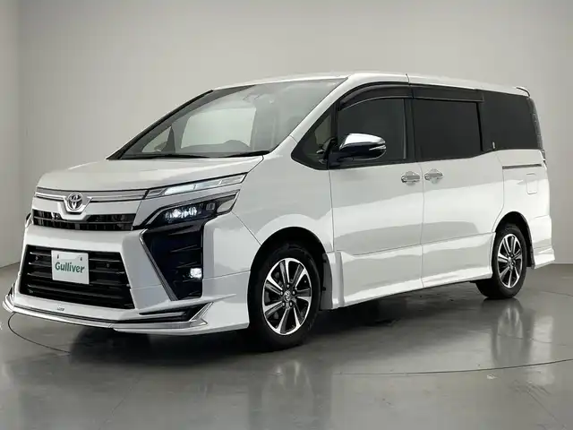 トヨタ ヴォクシー ZS 煌Ⅲ 愛知県 2021(令3)年 5.3万km ホワイトパールクリスタルシャイン 7人乗り/モデリスタエアロ　（フロント/リア）/純正12.1インチフリップダウンモニター/黒ハーフレザーシート/純正10インチSDナビ【NSZN-Z68T】/(HDMI/AM/FM/Bluetooth/CD/DVD/フルセグTV)/バックカメラ/ビルトインETC/オートライト/Toyota Safety Sense/・PCS(プリクラッシュセーフティ)/・LDA(レーンディパーチャーアラート)/・オートマチックハイビーム/・先行車発進告知機能/PKSB(パーキングサポートブレーキ)/クルーズコントロール/クリアランスソナー/コーナーセンサー/アイドリングストップ/盗難防止装置/横滑り防止機能/社外前後ドライブレコーダーCOMTEC【DC-DR652】/USB充電ソケット/電格ウィンカーミラー/プッシュスタート/純正フロアマット/純正16インチアルミホイール/ステアリングスイッチ/ISOFIX/フロントフォグランプ/ドアバイザー