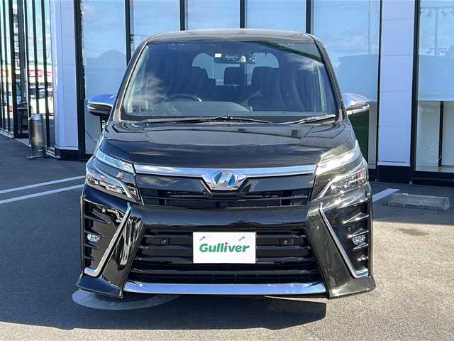 トヨタ ヴォクシー ハイブリッド ZS 煌Ⅱ 大阪府 2019(令1)年 3.2万km イナズマスパーキングブラックガラスフレーク 社外SDナビ/トヨタセーフティセンス/ＥＴＣ/シートヒーター/フリップダウンモニター/両側パワースライドドア/アイドリングストップ/プッシュスタート/スマートキー/バックカメラ/前後ドライブレコーダー/3列シート/パワーステアリング/パワーウィンドウ/パーキングアシスト/アイドリングストップ/エアコンWAC/Blue tooth接続/CDチェンジャー/ミュージックサーバー/純正フロアマット/シートヒーター運転席・助手席/純正アルミホイール/ABS/横滑り防止装置/コーナーセンサー前後/レーンキープアシスト/盗難防止装置/オートライト/オートマチックハイビーム/ハロゲンヘッドライト/エアバッグW/衝突被害軽減システム