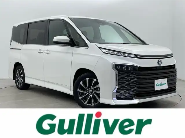 トヨタ ヴォクシー ハイブリッド S－Z 富山県 2025(令7)年 1.4万km ホワイトパールクリスタルシャイン 純正10.5型ディスプレイオーディオ/（AM/FM/DVD/BT/USB/HDMI/フルセグ）/バックカメラ/ビルトインETC2.0/ハーフレザーシート/D/N席シートヒーター/両側パワースライドドア/衝突被害軽減システム/レーダークルーズコントロール/レーンキープアシスト/コーナーセンサー/横滑り防止装置/アイドリングストップ/純正アルミホイール/オートLEDライト/オートマチックハイビーム/革巻きステアリング/ステアリングスイッチ/スマートキー/スペアキー