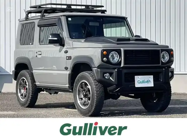 スズキ ジムニー XC 熊本県 2021(令3)年 3.4万km ミディアムグレー 社外SDナビ/・AM/FM/CD/DVD/BT/SD/HDMI/・フルセグTV/・フロント/バックカメラ/スズキセーフティサポート/・デュアルセンサーブレーキサポート/・車線逸脱警報機能/・ふらつき警報機能/・標識認識機能/・ハイビームアシスト/・先行車発進お知らせ/ダムド仕様グリル/社外前後バンパー/ルーフキャリア/オーバーフェンダー/背面タイヤ/ボンネットフードカバー/シートカバー/前席シートヒーター/クルーズコントロール/社外サスペンション/革巻きステアリング/・ステアリングスイッチ/ドライブレコーダー/オートライト/LEDライト/社外スロットルコントローラー/横滑り防止装置/電動格納ミラー/社外フロアマット/ドアバイザー/プッシュスタート/スペアキー2個