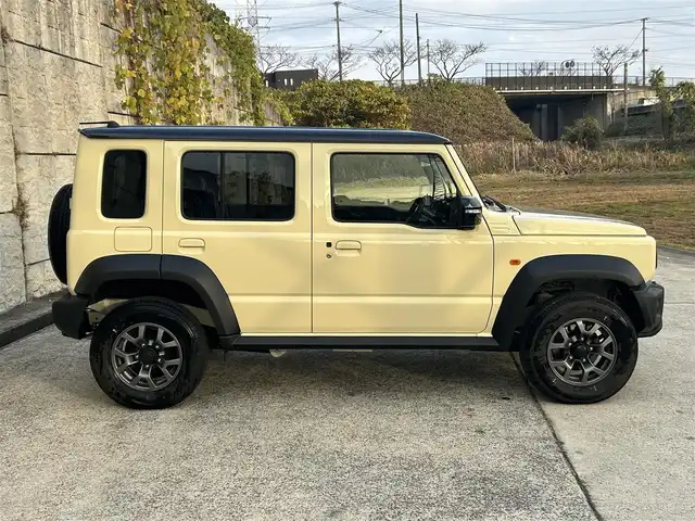 スズキ ジムニー ノマド FC 長崎県 2025(令7)年 0.3万km ベージュⅡ ワンオーナー/衝突軽減システム/レーンアシスト/レーダークルーズ/シートヒーター/スマートキー/プッシュスタート/電動格納ミラー/アイドリングストップ/純正15インチAW