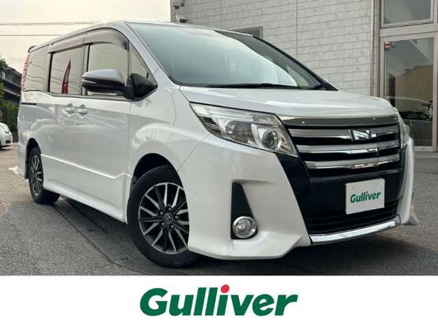 トヨタ ノア Si 愛知県 2015(平27)年 11.2万km ホワイトパールクリスタルシャイン 純正ナビ（NSZT-W64）/　CD/DVD/BT/SD/AM/FM/フルセグTV/バックカメラ/片側電動スライドドア/ETC/純正フリップダウンモニター/リアサンシェード/純正フロアマット/純正ドアバイザー/LEDヘッドライト/フォグランプ/ウインカーミラー/スマートキー×２