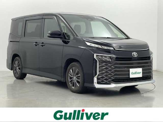 トヨタ ヴォクシー S－G 熊本県 2023(令5)年 2.2万km アティチュードブラックマイカ 純正10.5インチディスプレイオーディオ　/（フルセグ・ＢＴ・ＣＤ・DVD・ApplCarPlay・AndroidAuto・HDMI・USB）　/バックカメラ/純正前方ドライブレコーダーDRTーH68A/ビルトインETC2.0/両側パワースライドドア/前後クリアランスソナー/トヨタセーフティーセンス/・プリクラッシュセーフティ/・レーントレーシングアシスト/・レーンディパーチャーアラート/・レーダークルーズコントロール/・アダブティブハイビームシステム/・ロードサインアシスト/・ドライバー異常対応システム/・発進お知らせ機能/・フロントクロストラフィックアラート/・レーンチェンジアシスト/横滑り防止/純正フロアマット/純正１６インチAW/オートライト/オートマチックハイビーム/LEDヘッドライト/スマートキー/プッシュスタート/スペアキー1本