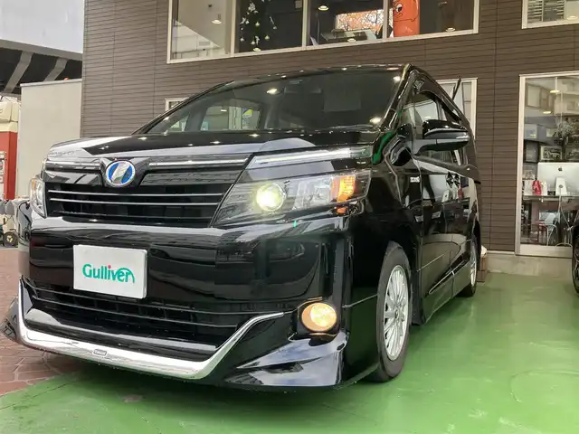 トヨタ ヴォクシー ハイブリッド V 神奈川県 2016(平28)年 12.2万km ブラック ワンオーナー/新車保証書/取扱説明書/スマートキー/スペアキー/純正ナビ・フルセグTV/CD・DVDビデオ・Bluetooth/バックカメラ/フリップダウンモニター/ビルトインETC/両側パワースライドドア/クルーズコントロール/前席シートヒーター/LEDヘッドライト/モデリスタエアロ/純正15インチアルミホイール