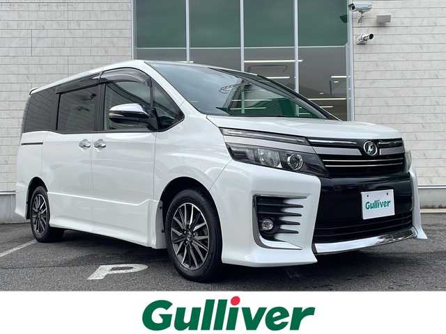 トヨタ ヴォクシー ZS 煌Ⅱ 鳥取県 2017(平29)年 10.3万km ホワイトパールクリスタルシャイン ワンオーナー/両側パワースライド/リヤクーラー/純正リヤスポイラー/純正メッキミラーカバー/純正16インチアルミ/純正フロアマット/純正ドアバイザー/社外メモリナビ/・フルセグTV、DVD、CD、SD、Bluetooth/社外フリップダウンモニター/バックカメラ/ETC/MTモード付AT/アイドリングストップ/レーンアシスト/オートハイビーム/オートライト/LEDライト/フォグランプ/横滑り防止装置/衝突被害軽減ブレーキ/スマートキー/スペアキー/新車保証書/取扱説明書