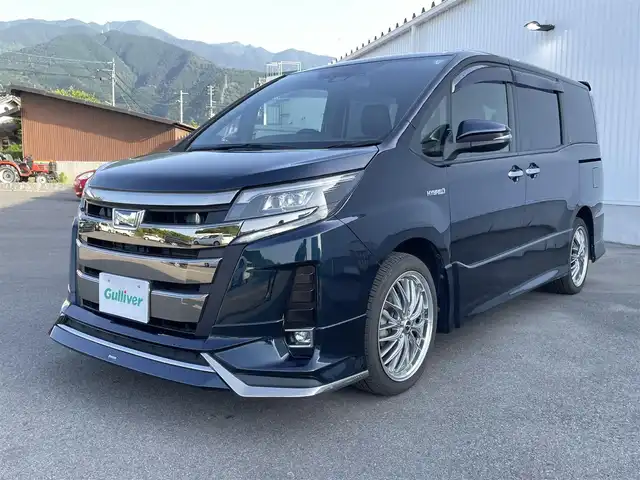 トヨタ ノア ハイブリッド Si ダブルバイビー 愛媛県 2018(平30)年 5.3万km ブラッキッシュアゲハガラスフレーク ワンオーナー/モデリスタエアロ/純正SDナビ【NSZN-Z61T】/(DVD/フルセグTV/Bluetooth/USB/MSV)/バックカメラ/フリップダウンモニター/両側パワースライドドア/TOYOTA Safety Sense/・レーダークルーズ コントロール/・プリクラッシュセーフティ/・レーントレーシングアシスト/・レーンディパーチャーアラート/・ロードサインアシスト/・先行車発進告知機能/・オートマチックハイビーム/前方ドライブレコーダー/ハーフレザーシート/前席シートヒーター/横滑り防止機能/スマートキー2個/プッシュスタート/LEDヘッドライト/ビルトインETC/新車時保証書/取扱説明書
