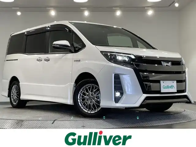 トヨタ ノア ハイブリッド Si ダブルバイビー 愛知県 2018(平30)年 4.9万km ホワイトパールクリスタルシャイン 純正９型Ｔコネクトナビ（NSZT-Y68T）/（AM/FM/Bluetooth/フルセグTV/SD/CD・DVD再生）/純正フリップダウンモニター　/トヨタセーフテセンスC　/　　-衝突軽減ブレーキ（プリクラッシュセーフティシステム）/　　-レーンディパーチャーアラート（LDA)/　　-オートマチックハイビーム/両側パワースライドドア　/シートヒーター　/ビルトインＥＴＣ　/バックカメラ　/クルーズコントロール/先行者発進お知らせ/ＵＳＢ接続　/ＬＥＤヘッドライト/LEDフォグランプ/純正フロアマット