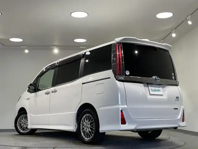 トヨタ ノア ハイブリッド Si ダブルバイビー 愛知県 2018(平30)年 4.9万km ホワイトパールクリスタルシャイン 純正９型Ｔコネクトナビ（NSZT-Y68T）/（AM/FM/Bluetooth/フルセグTV/SD/CD・DVD再生）/純正フリップダウンモニター　/トヨタセーフテセンスC　/　　-衝突軽減ブレーキ（プリクラッシュセーフティシステム）/　　-レーンディパーチャーアラート（LDA)/　　-オートマチックハイビーム/両側パワースライドドア　/シートヒーター　/ビルトインＥＴＣ　/バックカメラ　/クルーズコントロール/先行者発進お知らせ/ＵＳＢ接続　/ＬＥＤヘッドライト/LEDフォグランプ/純正フロアマット