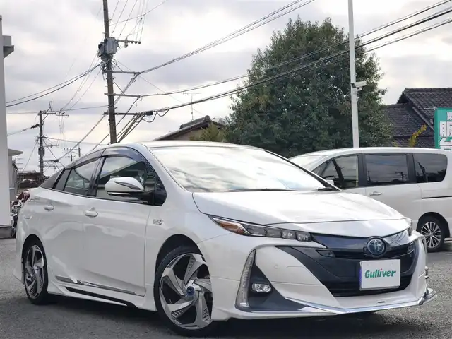 トヨタ プリウス ＰＨＶ A プレミアムナビパッケージ 熊本県 2020(令2)年 9.6万km ホワイトパールクリスタルシャイン モデリスタフルエアロ/モデリスタ18インチAW/充電プラグ車載/11.6インチT-Connectナビゲーションシステム/【フルセグTV/Bluetooth/AM/FM】/パノラミックビューモニター/レーダークルーズコントロール/プリクラッシュセーフティー/クリアランスソナー/レーンディパーチャーアラート/パーキングサポートブレーキ/ブラインドスポットモニター/ヘッドアップディスプレイ/オートLEDライト/オートハイビーム/ウィンカーミラー/レザーシート/D席パワーシート/前席シートヒーター/エアシート/革巻きステアリング/ステアリングスイッチ/ドライブレコーダー前後/ETC2.0/横滑り防止装置/純正フロアマット/純正ドアバイザー/保証書/スペアキー