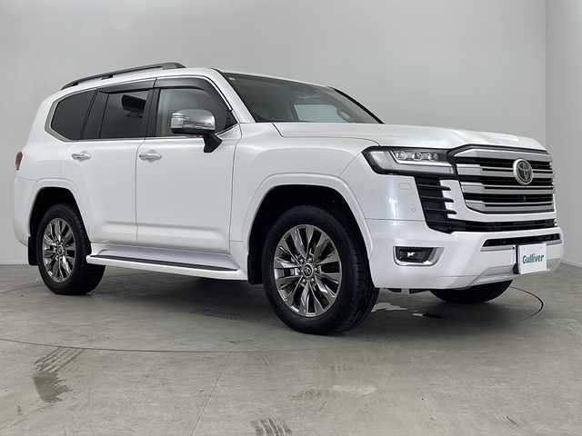 トヨタ ランドクルーザー ZX 鹿児島県 2023(令5)年 0.2万km プレシャスホワイトパール 純正JBLサウンド12.3インチディスプレイオーディオ/（CD/DVD/BT/Br/フルセグTV）/パノラミックビューモニター/トヨタセーフティセンス/レーダークルーズコントロール/ブラインドスポットモニター/サンルーフ/リアエンターテインメントシステム/マルチテレインセレクト/ベージュ革シート/メモリ付きパワーシート/シートヒーター/シートベンチレーション/ステアリングヒーター/パワーバックドア/電動格納サードシート/オートライト/オートハイビーム/電動パーキングブレーキ/オートホールド機能/純正フロアマット/純正バイザー/保証書、取説