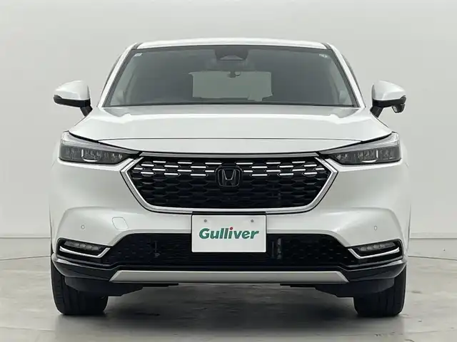 ホンダ ヴェゼル ハイブリッド e:HEV Z 群馬県 2023(令5)年 2.3万km プラチナホワイトパール 純正オプションフロントグリル/純正9インチディスプレイオーディオ/AM/FM/Bluetooth/USB/Apple Car Play/Android Auto/ワイヤレス充電器/ETC2.0車載機/マルチビューカメラシステム/プレミアムオーディオ/後退出庫サポート/＝＝＝＝＝＝/Honda SENSING/ ・衝突軽減ブレーキ/近距離衝突軽減ブレーキ/ ・誤発進抑制機能/後方誤発進抑制機能/ ・歩行者事故低減ステアリング/ ・路外逸脱抑制機能/ ・渋滞追従機能付アダプティブクルーズコントロール/ ・車線維持支援システム/ ・トラフィックジャムアシスト/ ・先行車発進お知らせ機能/ ・標識認識機能/ ・オートハイビーム/アダプティブドライビングビーム/ ・パーキングセンサーシステム/ ・ブラインドスポットインフォメーション/ハンズフリーアクセスパワーテールゲート(予約クローズ機能付)/前席シートヒーター/ステアリングヒーター/パドルシフト/親水/ヒーテッドドアミラー＋熱線入りフロントウインドウ/社外前後方ドライブレコーダー(ミラー型)/電動パーキングブレーキ/オートブレーキホールド/プッシュスタート/スマートキー/スペアキー有