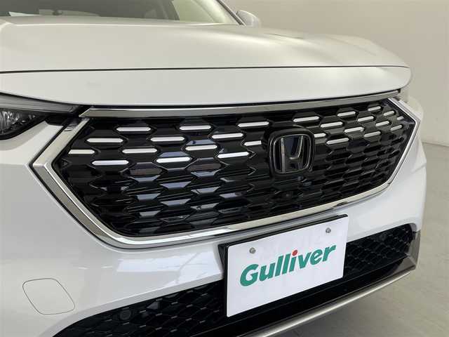 ホンダ ヴェゼル ハイブリッド e:HEV Z 群馬県 2023(令5)年 2.3万km プラチナホワイトパール 純正オプションフロントグリル/純正9インチディスプレイオーディオ/AM/FM/Bluetooth/USB/Apple Car Play/Android Auto/ワイヤレス充電器/ETC2.0車載機/マルチビューカメラシステム/プレミアムオーディオ/後退出庫サポート/＝＝＝＝＝＝/Honda SENSING/ ・衝突軽減ブレーキ/近距離衝突軽減ブレーキ/ ・誤発進抑制機能/後方誤発進抑制機能/ ・歩行者事故低減ステアリング/ ・路外逸脱抑制機能/ ・渋滞追従機能付アダプティブクルーズコントロール/ ・車線維持支援システム/ ・トラフィックジャムアシスト/ ・先行車発進お知らせ機能/ ・標識認識機能/ ・オートハイビーム/アダプティブドライビングビーム/ ・パーキングセンサーシステム/ ・ブラインドスポットインフォメーション/ハンズフリーアクセスパワーテールゲート(予約クローズ機能付)/前席シートヒーター/ステアリングヒーター/パドルシフト/親水/ヒーテッドドアミラー＋熱線入りフロントウインドウ/社外前後方ドライブレコーダー(ミラー型)/電動パーキングブレーキ/オートブレーキホールド/プッシュスタート/スマートキー/スペアキー有