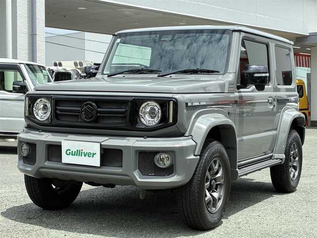 スズキ ジムニー シエラ JC 熊本県 2021(令3)年 1.7万km ミディアムグレー ダムドリトルGスタンダード/・フロントグリル（エンブレムスズキ）/・フロントバンパー/・オーバーフェンダー＆アルミサイドモール/・スペアタイヤカバー/・G15エンブレム/社外10V型有機ELディスプレイナビ（CN-F1X10LD）/【フルセグTV/Bluetooth再生/CD/DVD】/バックカメラ/デュアルセンサーブレーキサポート/車線逸脱警報システム/クルーズコントロール/レザー調シートカバー/シートヒーター/革巻きステアリング/ステアリングスイッチ/LEDオートライト/フォグライト/ETC/保証書/取扱説明書