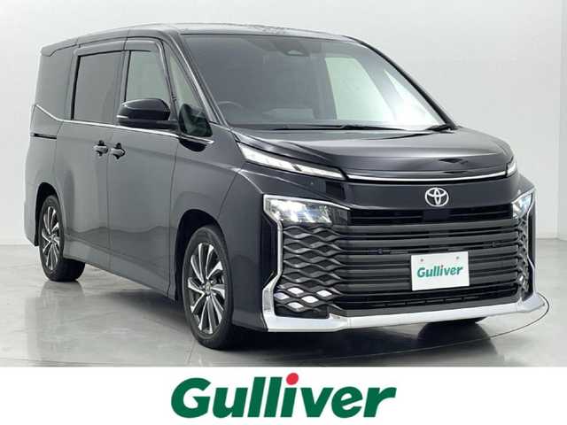 トヨタ ヴォクシー S－Z 熊本県 2022(令4)年 3.8万km アティチュードブラックマイカ 純正ナビ/　（HDMI・Bluetooth・フルセグ）/バックカメラ/純正フリップダウンモニター/デジタルミラー型ドライブレコーダー/トヨタセーフティセンス/・プリクラッシュセーフティ/・レーントレーシングアシスト/・レーンディパーチャーアラート/・レーダークルーズコントロール/・オートマチックハイビー/・駐車時支援パーキングサポートシステム/・ロードサインアシスト/・先行車発進お知らせ機能/横滑り防止/両側パワースライドドア/ビルトインETC2.0/前席シートヒーター/電動パーキングブレーキ/ブレーキホールド/オートライト/LEDヘッドライト/ハーフレザーシート/社外フロアマット/純正17インチAW/スマートキー/プッシュスタート/スペアキー1本/保証書/取扱説明書