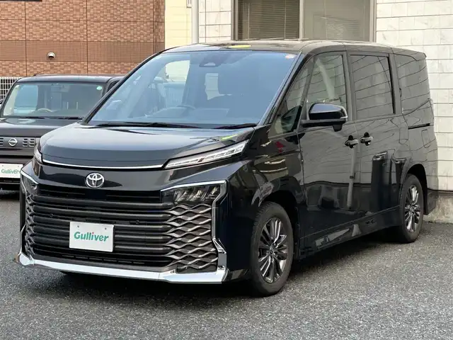 トヨタ ヴォクシー S－G 福岡県 2022(令4)年 2.6万km グリッターブラックガラスフレーク ワンオーナー/純正8インチディスプレイオーディオ/　（AM/FM/Bluetooth/Miracast/ナビキット）/バックカメラ/トヨタセーフティーセンス/・プリクラッシュセーフティ/・レーントレーシングアシスト/・レーンディバーチャーアラート/・オートマッチクハイビーム/・プロアクティブドライビングアシスト/・発進遅れ告知機能/・ロードサインアシスト/・レーダークルーズコントロール/・ドライバー異常時対応システム/コーナーセンサー/クリアランスソナー/横滑り防止装置/オートライト/純正16インチアルミホイール/左側パワースライドドア/電格ウインカーミラー/ビルトインETC2.0/サンシェード/3列シート/純正フロアマット/ISOFIX/プッシュスタート/盗難防止装置/電源ソケット×1/スペアキー×1/保証書/取扱説明書/ナビ取扱説明書