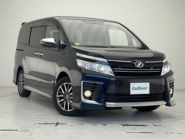 トヨタ ヴォクシー ZS 煌 沖縄県 2015(平27)年 7.1万km ブラッキッシュアゲハガラスフレーク 社外8インチナビ(ＭＤＶ－Ｘ８０２Ｌ)/(フルセグＴＶ　Ｂｌｕｅｔｏｏｔｈ　ＣＤ　ＤＶＤ)　/両側パワースライドドア　/バックカメラ　/ビルトインＥＴＣ　　/ステアリングスイッチ/アイドリングストップ　/スマートキー/プッシュスタート/ＬＥＤヘッドライト　/オートライト　/純正16インチアルミホイール/純正フロアマット/横滑り防止装置/ドアバイザー