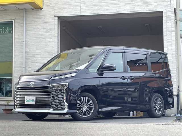 トヨタ ヴォクシー ハイブリッド S－G 大分県 2023(令5)年 0.4万km ダークグレーM/クリスタルシルバーM 両側パワースライドドア /全方位カメラ/純正10.5インチアルミホイール/フルセグTV/Bluetooth/純正16インチアルミホイール/純正ビルトインETC/純正LEDヘッドライト/オートライト/オートマチックハイビーム/衝突被害軽減ブレーキ/横滑り防止装置/コーナーセンサー/シートヒーター/スペアキー