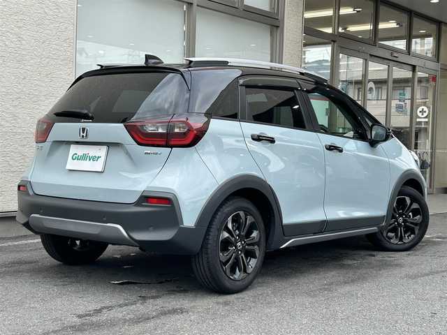 ホンダ フィット e:HEVクロスター 大阪府 2023(令5)年 0.6万km フィヨルドミストパール ワンオーナー/純正8インチナビ(BT/CD)/レーダークルーズコントロール/フロントカメラ/バックモニター/レーンキープアシスト/衝突被害軽減システム/横滑り防止装置/前後コーナーセンサー/ハーフレザーシート/純正フロアマット/純正１６インチAW/ルーフレール/ETC/取扱説明書/保証書/スペアキー　あり
