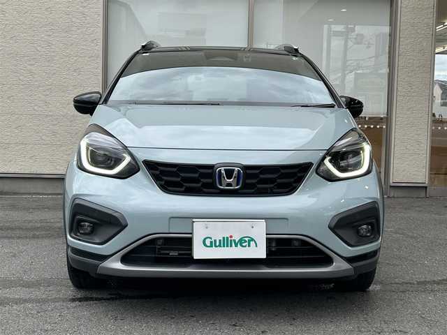 ホンダ フィット e:HEVクロスター 大阪府 2023(令5)年 0.6万km フィヨルドミストパール ワンオーナー/純正8インチナビ(BT/CD)/レーダークルーズコントロール/フロントカメラ/バックモニター/レーンキープアシスト/衝突被害軽減システム/横滑り防止装置/前後コーナーセンサー/ハーフレザーシート/純正フロアマット/純正１６インチAW/ルーフレール/ETC/取扱説明書/保証書/スペアキー　あり