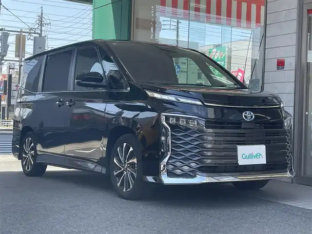 トヨタ ヴォクシー ハイブリッド S－Z 愛知県 2024(令6)年 0.9万km アティチュードブラックマイカ ワンオーナー/10.5型ディスプレイオーディオプラス〈MOP〉/・コネティッドナビ／DDV／地デジTV/・HDMI／Bluetooth／Miracast/快適利便パッケージ High〈MOP〉/・両側パワースライドドア/・パワーバックドア/・2列目シートヒーター＆オットマン/・ナノイーX/・ステアリングヒーター/ドライビングサポートパッケージ〈MOP〉/・デジタルインナーミラー/・ヘッドアップディスプレイ/プロジェクター式LEDヘッドライト〈MOP〉/・アダプティブハイビームシステム/合皮＆ファブリックコンビシート/前席＆2列目シートヒーター/ビルトインETC2.0/後席/荷室アクセサリーコンセント/TOYOTA SAFETY SENSE/・プリクラッシュセーフティ/・レーントレーシングアシスト/・レーンディパーチャーアラート/・レーダークルーズコントロール/・オートマチックハイビーム/・ロード－サインアシスト/・先行車発進告知/スマートキー＆プッシュスタート/純正17インチAW