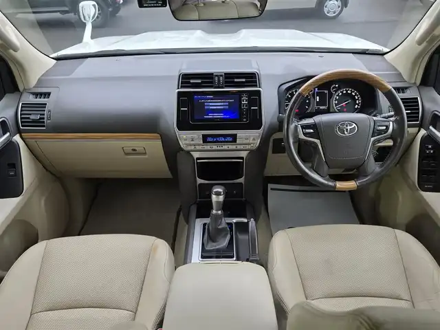 トヨタ ランドクルーザー プラド TX Lパッケージ 鹿児島県 2018(平30)年 5万km ホワイトパールクリスタルシャイン 前後モデリスタエアロ　/ムーンルーフ　/ヒッチメンバー　/ヒッチキャリア　/ラゲージプロテクター　/ＡＬＰＩＮＥナビ　/ウッドコンビステア　/純正サイドステップカバー　/ルーフレール　/純正アルミホイール（１９インチ）/前後コーナーセンサー/Bluetoothオーディオ/フルセグテレビ/D+N席シートヒーター/D+N席シートベンチレーション/D+N席パワーシート/電動格納サードシート/社外フロアマット/プッシュスタート/スマートキー/横滑り防止装置/レーンキープアシスト