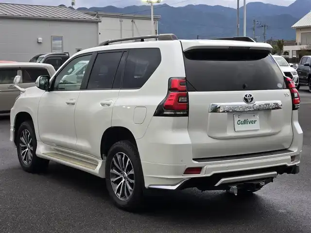 トヨタ ランドクルーザー プラド TX Lパッケージ 鹿児島県 2018(平30)年 5万km ホワイトパールクリスタルシャイン 前後モデリスタエアロ　/ムーンルーフ　/ヒッチメンバー　/ヒッチキャリア　/ラゲージプロテクター　/ＡＬＰＩＮＥナビ　/ウッドコンビステア　/純正サイドステップカバー　/ルーフレール　/純正アルミホイール（１９インチ）/前後コーナーセンサー/Bluetoothオーディオ/フルセグテレビ/D+N席シートヒーター/D+N席シートベンチレーション/D+N席パワーシート/電動格納サードシート/社外フロアマット/プッシュスタート/スマートキー/横滑り防止装置/レーンキープアシスト