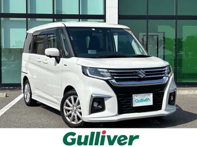 スズキ ソリオ HV MZ 和歌山県 2023(令5)年 2.3万km ピュアホワイトP 純正9インチナビ/フルセグTV/Bluetooth/CD/DVD/USB/アラウンドビューモニター/ETC/衝突軽減カメラ/車線逸脱防止機能/コーナーセンサー/レーダークルーズコントロール/HUD（ヘッドアップディスプレイ）/両側パワースライドドア/革巻きステアリング/ステアリングスイッチ/前席シートヒーター/リアドアサンシェード/後席サーキュレーター/LEDヘッドライト/フォグランプ/オートライト/電動格納ミラー/フルオートエアコン/アイドリングストップ/社外15インチAW/ドアバイザー/純正フロアマット/プッシュスタート/スマートキー
