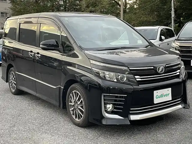 トヨタ ヴォクシー ZS 千葉県 2014(平26)年 9.5万km ブラック 純正ディーラーナビ(AM/FM/DVD/CD/BT/USB/HDMI/フルセグ)/フリップダウンモニター/バックカメラ/両側パワースライドドア/アイドリングストップ/ステアリングリモコン/エコモード機能/横滑り防止機能/LEDヘッドライト/ETC/プッシュスタート/電動格納ミラー/バニティランプ/後部座席窓サンシェード
