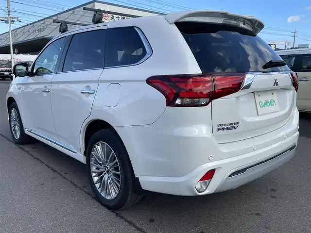三菱 アウトランダー ＰＨＥＶ G 岡山県 2018(平30)年 7.5万km シルキーホワイト 登録時走行距離：　74184km/禁煙車/全方位カメラ/純正ナビ(型番：CN-H500WD)/　(CD/DVD/フルセグTV/Bluetooth)/フリップダウンモニター/ルーフキャリア/クルーズコントロール(追従走行あり)/衝突被害軽減システム/車線逸脱警報（レーンキープアシスト）/コーナーセンサー/後側方車両検知警報(ブラインドスポットモニター)/ETC/ルーフラック/Clazzioレザー調シートカバー/シートヒーター/パワーシート/パワーバックドア/ステアリングヒーター/革巻きステアリング/ステアリングスイッチ/純正LEDヘッドライト/フォグライト/オートライト/プッシュスタート/スマートキー/スペアキー/パドルシフト/アイドリングストップ/純正アルミホイール 18インチ/電動格納ミラー/純正フロアマット/横滑防止装置/盗難防止装置