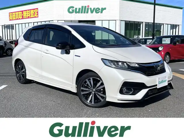 ホンダ フィット ハイブリット S ホンダセンシング 鳥取県 2018(平30)年 5.7万km プレミアムホワイトパールⅡ 純正ナビ／ＴＶ／ＤＶＤ／ＣＤ／ＢＴ/バックカメラ/ビルトインＥＴＣ/ドライブレコーダー/ホンダセンシング/レーダークルーズコントロール/レーンアシスト/パドルシフト/ＬＥＤヘットライト/フォグライト/純正エアロパーツ/リヤルーフスポイラー/純正１６インチアルミホイール/プッシュエンジンスタート/アイドリングストップ/フロアマット/ドアバイザー