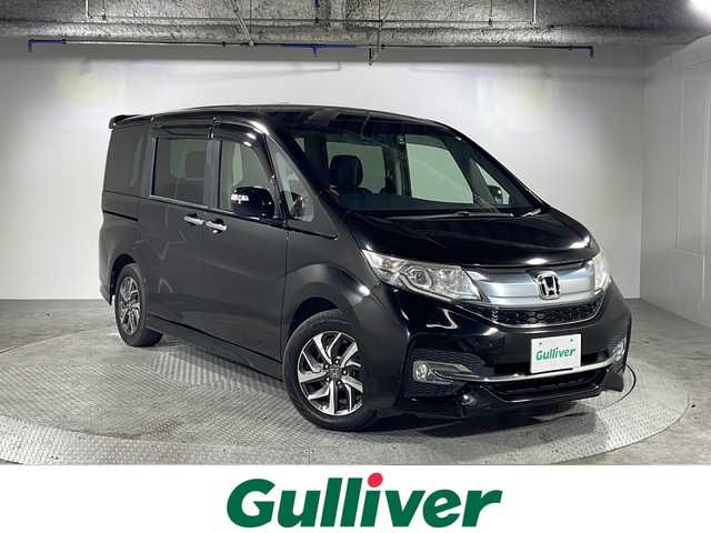 ホンダ ステップワゴン スパーダ 沖縄県 2015(平27)年 10.1万km プレミアムスパークルブラックパール 禁煙車/７人乗り/純正７インチナビ/【CD/DVD/フルセグTV/BT】/バックカメラ/９インチ純正後席フリップダウンモニター/前後ドライブレコーダー/ETC/クルーズコントロール/両側パワースライドドア/横滑り防止装置/全席革調シートカバー/LEDヘッドライト/オートライト/１６インチ純正アルミ/スマートキー