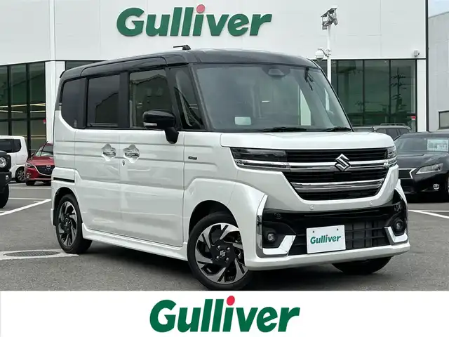 スズキ スペーシア カスタム HYBRID XS 愛媛県 2023(令5)年 0.1千km ピュアホワイトパール/ブラック2トーン 登録時走行距離：8Km/横滑り防止装置/衝突軽減システム/レーンキープアシスト/パーキングアシスト/アイドリングストップ/エンジンスタートボタン/追従クルコン/ＡＢS/LEDヘッドライト/オートライト/両側パワスラ/スマートキー/ハンドルヒーター/シートヒーター/純正アルミホイール