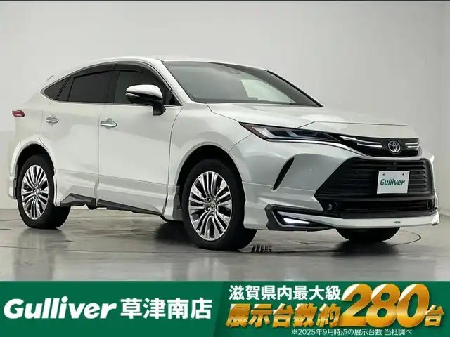トヨタ ハリアー ハイブリッド Z レザーパッケージ 滋賀県 2021(令3)年 3.1万km ホワイトパールクリスタルシャイン 純正12.3インチナビ/【Bluetooth/USB/フルセグ 】/JBLプレミアムサウンド/パノラミックビューモニター/モデリスタエアロ/黒本革シート/D/Nパワーシート/D/Nシートヒーター/D/Nシートベンチレーション/ステアリングヒーター/パワーリアゲート/前後ドラレコ/前後ソナー/トヨタセーフティセンス/【PCS/BSM/RCTA/RSA/HUD】/レーダークルーズコントロール/ビルトインETC2.0/MTモード付AT/純正デジタルインナーミラー/プッシュスタート/スマートキー/ステアリングリモコン/電動テレスコチルト/LEDヘッドライト