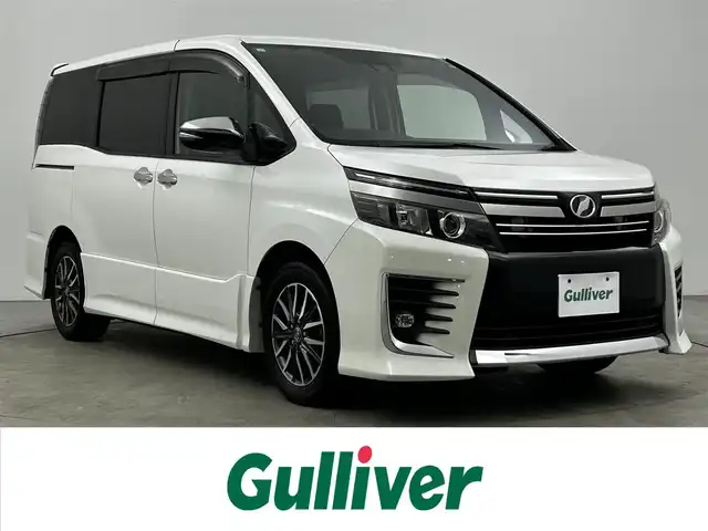 トヨタ ヴォクシー ZS 煌Ⅱ 大分県 2017(平29)年 9.4万km ホワイトパールクリスタルシャイン ワンオーナー/純正SDナビ（NSZT-Y66T）/両側パワースライドドア/バックカメラ/オートライト/オートマチックハイビーム/3列シート/ウォークスルー/チップアップシート/レーンキープアシスト/アイドリングストップ/純正フロアマット/純正アルミホイル16インチ/ETC/LEDヘッドライト