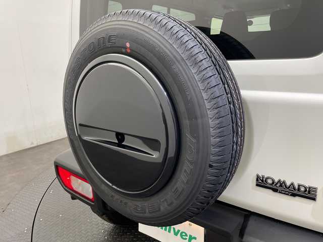 スズキ ジムニー ノマド FC 愛媛県 2025(令7)年 0.1千km アークティックホワイトパール 登録済未使用車／アダプティブクルーズコントロール／シートヒーター／純正１５インチアルミホイール／ＬＥＤヘッドライト／オートライト／オートマチックハイビーム／スマートキー／プッシュスタート／背面タイヤ