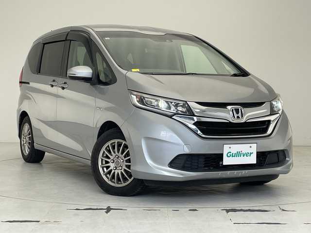 ホンダ フリード ハイブリット G ホンダセンシング 沖縄県 2016(平28)年 8.6万km ルナシルバーM 純正９インチナビ(VXM-175VFNI)　/(フルセグＴＶ　ＣＤ　ＤＶＤ　Bluetooth)　/フリップダウンモニター　/バックカメラ　/ＥＴＣ　/ドライブレコーダー前後　/ホンダセンシング/●衝突軽減ブレーキ〈CMBS〉/●誤発進抑制機能/●ACC〈アダプティブ・クルーズ・コントロール〉/●LKAS〈車線維持支援システム〉/●歩行者事故低減ステアリング/●路外逸脱抑制機能/●先行車発進お知らせ機能/●標識認識機能/両側パワースライドドア　/純正フロアマット　/ＬＥＤヘッドライト/オートヘッドライト/プッシュスタート/スマートキー/純正フロアマット/保証書/取扱説明書