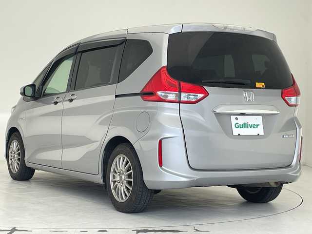 ホンダ フリード ハイブリット G ホンダセンシング 沖縄県 2016(平28)年 8.6万km ルナシルバーM 純正９インチナビ(VXM-175VFNI)　/(フルセグＴＶ　ＣＤ　ＤＶＤ　Bluetooth)　/フリップダウンモニター　/バックカメラ　/ＥＴＣ　/ドライブレコーダー前後　/ホンダセンシング/●衝突軽減ブレーキ〈CMBS〉/●誤発進抑制機能/●ACC〈アダプティブ・クルーズ・コントロール〉/●LKAS〈車線維持支援システム〉/●歩行者事故低減ステアリング/●路外逸脱抑制機能/●先行車発進お知らせ機能/●標識認識機能/両側パワースライドドア　/純正フロアマット　/ＬＥＤヘッドライト/オートヘッドライト/プッシュスタート/スマートキー/純正フロアマット/保証書/取扱説明書