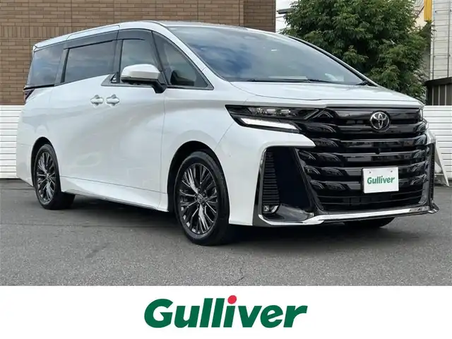 トヨタ ヴェルファイア ハイブリット Z プレミア 群馬県 2025(令7)年 0.8万km プラチナホワイトパールマイカ ワンオーナー/ガラスルーフ/純正メモリナビ/(BT/フルセグTV)/全周囲カメラ/後席フリップダウンモニター/追従機能付きクルーズコントロール/両側パワースライドドア/電動リアゲート/ETC2.0/盗難防止装置/オットマン/シートヒーター(D/Nセカンドシート)/ステアリングヒーター/プッシュスタート/スマートキー×２/保証書