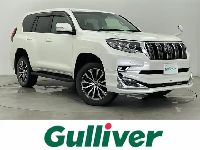 トヨタ ランドクルーザー プラド TX Lパッケージ 富山県 2019(平31)年 4.3万km パール 4WD/モデリスタエアロ/社外ディスプレイオーディオ（CD/DVD/BT）/バックカメラ/黒革シート/レーダークルーズコントロール/衝突被害軽減ブレーキ/クリアランスソナー/レーンキープアシスト/前席パワーシート/前席シートヒーター/エアシート/LEDヘッドライト/オートライト/ラゲッジマット/プッシュスタート/純正フロアマット