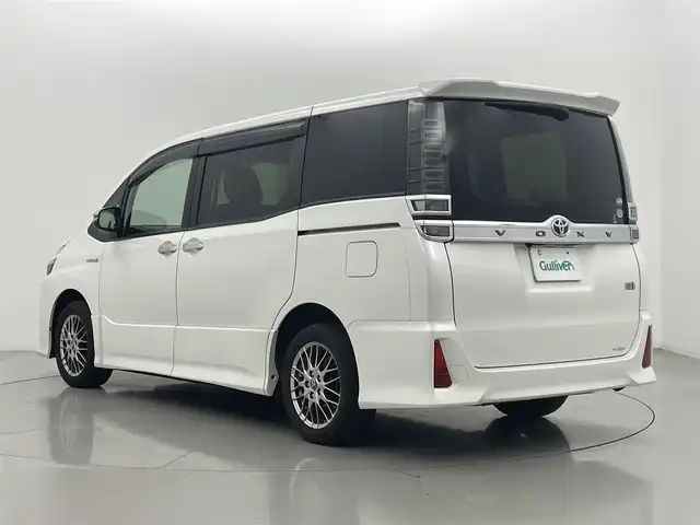 トヨタ ヴォクシー ハイブリッド ZS 煌 熊本県 2018(平30)年 6.4万km ホワイトパールクリスタルシャイン ワンオーナー/禁煙車/純正9インチメモリナビ【NSZT-Y68T】/フルセグTV・BT・CD・DVD・FM・AM/バックカメラ/ビルトインETC/クルーズコントロール/トヨタセーフティーセンス/・プリクラッシュセーフティ/・レーンディパーチャーアラート/・オートハイビーム/両側パワースライドドア/横滑り防止/純正LEDヘッドライト/革調シートカバー/前席シートヒーター/革巻きステアリング/ステアリングスイッチ/リアオートエアコン/純正16インチアルミホイール/スマートキー/プッシュスタート/スペアキー1本/保証書/取扱説明書