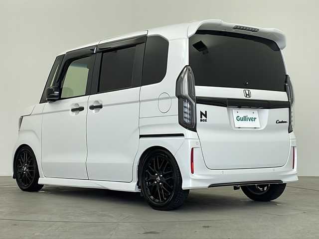 ホンダ Ｎ ＢＯＸ カスタム L ターボ スタイル+ブラック 鹿児島県 2023(令5)年 2.6万km プラチナホワイトパール 純正9インチナビ/（AM/FM/CD/DVD/Bluetooth）/バックカメラ/ビルトインETC/前席シートヒーター/両側パワースライドドア/TEIN車高調/ステアリングリモコン/パドルシフト/LEDオートライト/LEDフォグランプ/シートバックテーブル/リアドアサンシェード/フロアマット/ドアバイザー/ホンダセンシング/衝突軽減ブレーキ（CMBS）/誤発進抑制機能/歩行者事故低減ステアリング/路外逸脱抑制機能/渋滞追従機能付アダプティブクルーズコントロール（ACC）/車線維持支援システム（LKAS）/先行車発進お知らせ機能/標識認識機能/後方誤発進抑制機能/オートハイビーム