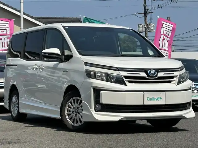 トヨタ ヴォクシー ハイブリッド V 大分県 2015(平27)年 11.9万km ホワイトパールクリスタルシャイン TRDエアロ/・フロントスポイラー/・サイドステップ/・リアハーフ/・フロントグリル/・フロントバンパーガーニッシュ/Toyota Safety Sense C/・プリクラッシュセーフティシステム/・レーンディパーチャーアラート/・オートマチックハイビーム/TOYOTA純正SDナビゲーション(NSZT-Y64T)/【フルセグTV/Bluetooth/DVD/CD/SD/AMFMラジオ】/TOYOTA純正11型後席ディスプレイ(V11-R62C)/両側パワースライドドア/バックカメラ/ETC/レーダークルーズコントロール/置くだけ充電/アイドリングストップ/先行車発進告知機能/車両接近通報装置/リアサンシェード/WAC/純正フロアマット/スマートキー1本/保証書/取扱説明書