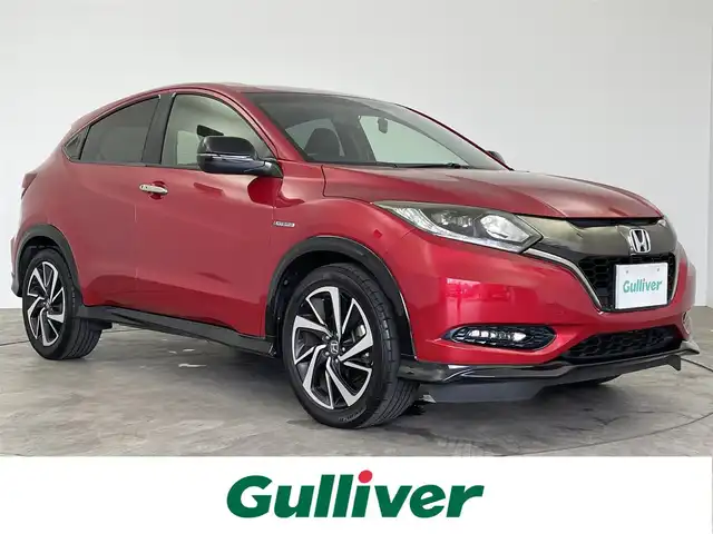 ホンダ ヴェゼル ハイブリッド RS ホンダセンシング 大分県 2017(平29)年 7万km プレミアムクリスタルレッドM 【 Honda SENSING 】/・衝突軽減ブレーキ 〈CMBS〉/・歩行者事故低減ステアリング/・ACC 〈アダプティブ・クルーズ・コントロール〉/・LKAS 〈車線維持支援システム〉/・路外逸脱抑制機能/・誤発進抑制機能/・先行車発進お知らせ機能/・標識認識機能/ワンオーナー/純正メモリーナビ/フルセグテレビ/バックカメラ/Bluetooth/DVD再生可能/ハーフレザーシート/社外ドライブレコーダー（フロント）/オートライト/ＬＥＤヘッドライト/ビルトインETC/スマートキー3個/純正フロアマット/純正18ＡＷ/D・N席シートヒーター