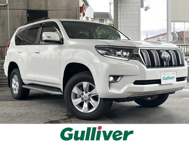トヨタ ランドクルーザー プラド TX Lパッケージ 京都府 2020(令2)年 1.6万km ホワイトパールクリスタルシャイン ワンオーナー　/黒本革シート　/純正８インチＳＤナビ　/フルセグＴＶ　/CD/DVD再生機能/Bluetooth/禁煙　/ＬＤＡ　/ＰＣＳ　/ルーフレール　/レーダークルーズコントロール/４ＷＤ　/ダウンヒルアシストコントロール/センターデフロック/パーキングアシスト/ＬＥＤヘッドライト/ウィンカーミラー/オートライト/オートマチックハイビーム/パワーシート　/電動格納サードシート　/シートヒーター　/エアシート　/フルフラットシート/ベンチシート/純正17インチＡＷ/ステアリングスイッチ/Wエアバッグ/カーテンエアバッグ/前後社外ドライブレコーダー(TZ-D205W)