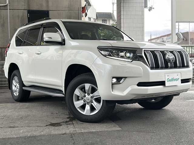トヨタ ランドクルーザー プラド TX Lパッケージ 京都府 2020(令2)年 1.6万km ホワイトパールクリスタルシャイン ワンオーナー　/黒本革シート　/純正８インチＳＤナビ　/フルセグＴＶ　/CD/DVD再生機能/Bluetooth/禁煙　/ＬＤＡ　/ＰＣＳ　/ルーフレール　/レーダークルーズコントロール/４ＷＤ　/ダウンヒルアシストコントロール/センターデフロック/パーキングアシスト/ＬＥＤヘッドライト/ウィンカーミラー/オートライト/オートマチックハイビーム/パワーシート　/電動格納サードシート　/シートヒーター　/エアシート　/フルフラットシート/ベンチシート/純正17インチＡＷ/ステアリングスイッチ/Wエアバッグ/カーテンエアバッグ/前後社外ドライブレコーダー(TZ-D205W)