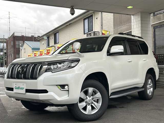 トヨタ ランドクルーザー プラド TX Lパッケージ 京都府 2020(令2)年 1.6万km ホワイトパールクリスタルシャイン ワンオーナー　/黒本革シート　/純正８インチＳＤナビ　/フルセグＴＶ　/CD/DVD再生機能/Bluetooth/禁煙　/ＬＤＡ　/ＰＣＳ　/ルーフレール　/レーダークルーズコントロール/４ＷＤ　/ダウンヒルアシストコントロール/センターデフロック/パーキングアシスト/ＬＥＤヘッドライト/ウィンカーミラー/オートライト/オートマチックハイビーム/パワーシート　/電動格納サードシート　/シートヒーター　/エアシート　/フルフラットシート/ベンチシート/純正17インチＡＷ/ステアリングスイッチ/Wエアバッグ/カーテンエアバッグ/前後社外ドライブレコーダー(TZ-D205W)