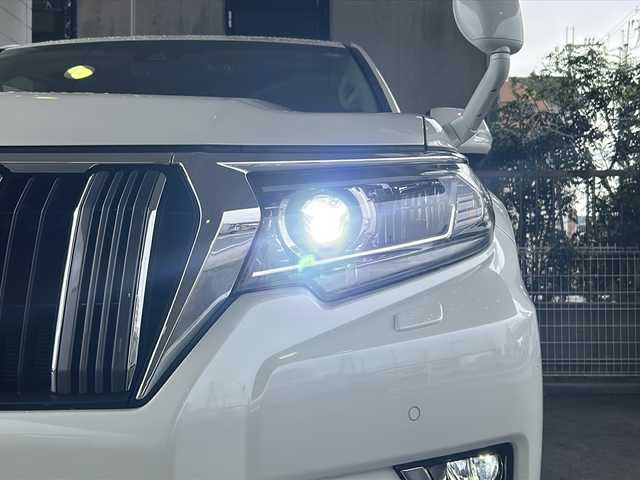 トヨタ ランドクルーザー プラド TX Lパッケージ 京都府 2020(令2)年 1.6万km ホワイトパールクリスタルシャイン ワンオーナー　/黒本革シート　/純正８インチＳＤナビ　/フルセグＴＶ　/CD/DVD再生機能/Bluetooth/禁煙　/ＬＤＡ　/ＰＣＳ　/ルーフレール　/レーダークルーズコントロール/４ＷＤ　/ダウンヒルアシストコントロール/センターデフロック/パーキングアシスト/ＬＥＤヘッドライト/ウィンカーミラー/オートライト/オートマチックハイビーム/パワーシート　/電動格納サードシート　/シートヒーター　/エアシート　/フルフラットシート/ベンチシート/純正17インチＡＷ/ステアリングスイッチ/Wエアバッグ/カーテンエアバッグ/前後社外ドライブレコーダー(TZ-D205W)