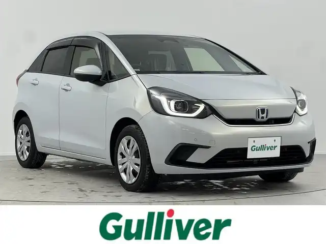 ホンダ フィット e:HEVホーム 熊本県 2020(令2)年 2.6万km プレミアムサンライトホワイトパール 純正8インチナビ/CD/DVD/フルセグTV/Bluetooth/ホンダセンシング/衝突軽減ブレーキ/路外逸脱抑制システム/踏み間違い衝突軽減ブレーキ/クリアランスソナー/横滑り防止/追従付きクルーズコントロール/ハーフレザーシート/ＬＥＤライト/前方ドライブレコーダー/ビルトインETC/USB入力/電子パーキング/ブレーキホールド/三点エアバック/スマートキー/スペアキー/純正フロアマット/ドアバイザー