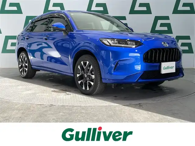 ホンダ ＺＲ－Ｖ ハイブリッド e:HEV Z 鹿児島県 2024(令6)年 1.4万km プレミアムクリスタルブルークリスタル 禁煙車/純正ナビ/(Ｂｌｕｅｔｏｏｔｈ/フルセグTV)/ホンダセンシング/　・衝突軽減ブレーキ（CMBS）/　・誤発進抑制機能/　・後方誤発進抑制機能/　・近距離衝突軽減ブレーキ/　・歩行者事故低減ステアリング/　・路外逸脱抑制機能/　・渋滞追従機能付アダプティブクルーズコントロール（ACC）/　・車線維持支援システム（LKAS）/　・トラフィックジャムアシスト（渋滞運転支援機能）/　・先行車発進お知らせ機能/　・標識認識機能/　・アダプティブドライビングビーム/　・ブラインドスポットインフォメーション/　・パーキングセンサーシステム/置くだけ充電/前席シートヒーター/BOSEプレミアムサウンドシステム/ステアリングヒーター/パワーテールゲート/ETC